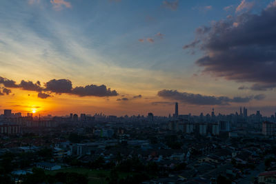 High angle view of buildings against cloudy sky during sunset