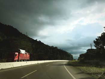 Empty road against cloudy sky