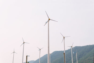 Windmills on landscape against sky