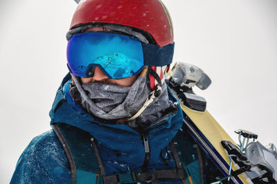 Closeup portrait of ski goggles of a man with reflection of snowy mountains. the mountain range is