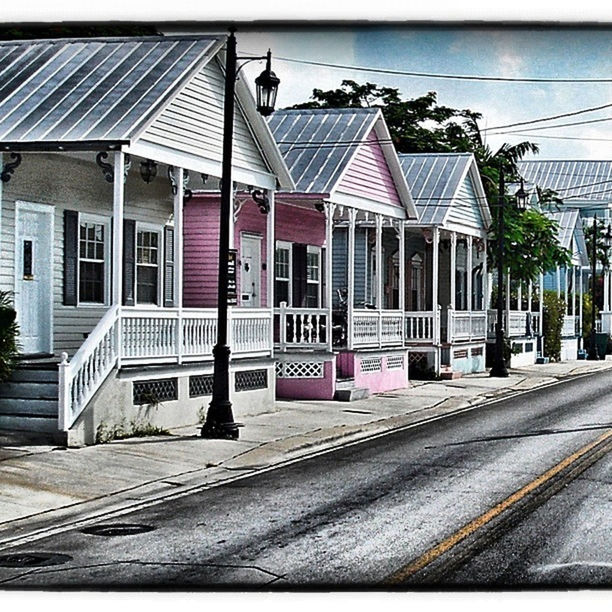 building exterior, architecture, built structure, city, street, animal themes, transportation, residential building, road, day, sky, residential structure, building, bird, house, power line, city life, outdoors, cable, incidental people