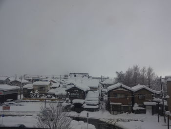 Snow covered houses and buildings against sky