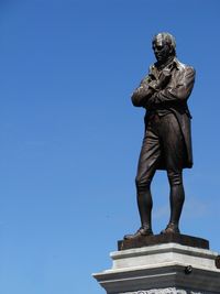 Low angle view of statue against clear blue sky