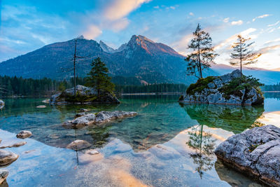 Scenic view of lake by mountains against sky