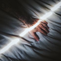 Cropped image of man hand on bed with sunlight