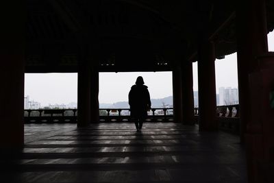 Rear view of silhouette man walking in water