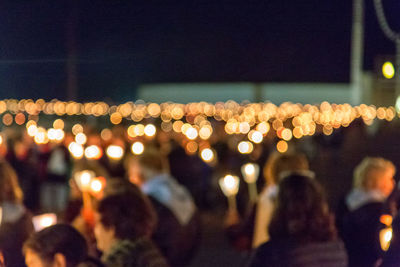 Defocused image of illuminated crowd at night