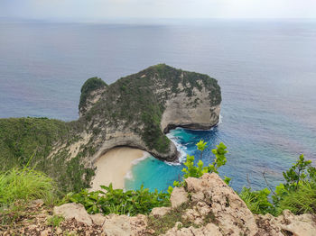 Scenic view of rocks on sea shore against sky