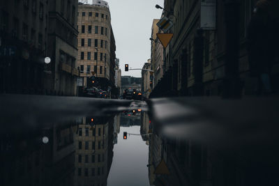 Reflection of buildings in puddle on street