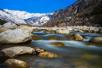 Scenic view of lake by mountains against sky