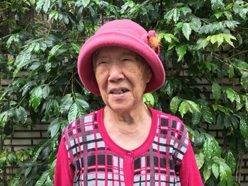 Senior woman looking away against plants