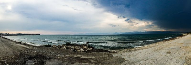 Scenic view of beach against cloudy sky