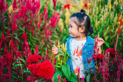Cute girl standing amidst plants