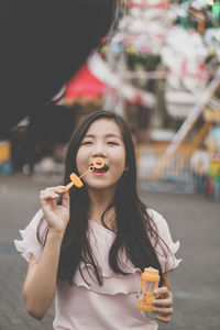 Young woman blowing bubble at amusement park