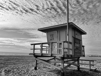 Lifeguard hut on beach against sky