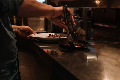 Midsection of man preparing food in restaurant