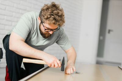 Side view of young man exercising at home