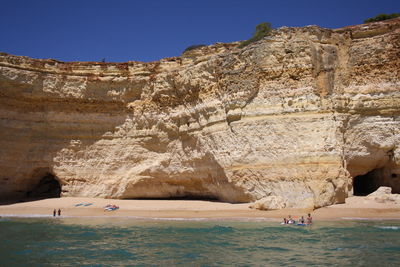 View of rocks in sea against clear sky