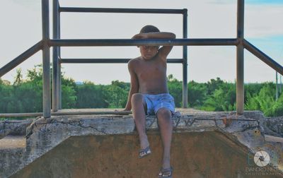 Full length of shirtless man against sky