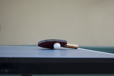 Table tennis racket and ball on table