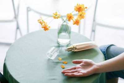 Midsection of woman holding vase on table