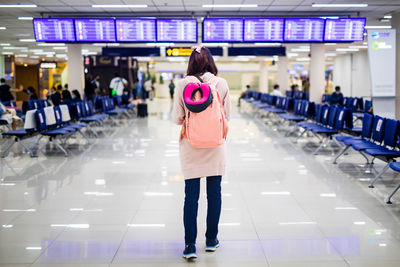 Rear view of woman standing at airport