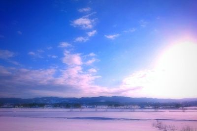 Scenic view of landscape against blue sky during winter