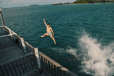 High angle view of man jumping on sea