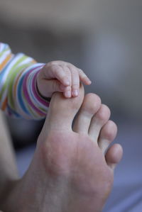 Baby holding father's toe