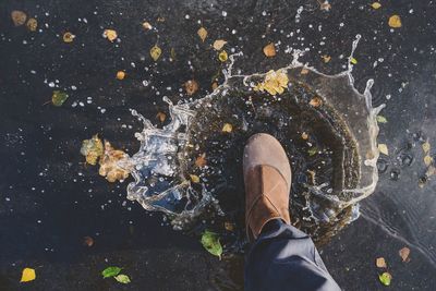 Low section of man walking in a rainy day of autumn