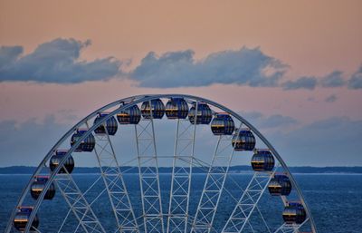 Ferris wheel in sea against sky