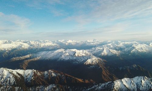 Scenic view of snowcapped mountains against blue sky