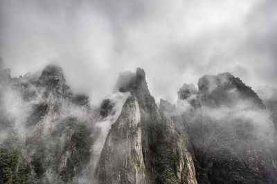 Scenic view of rocky mountains against cloudy sky