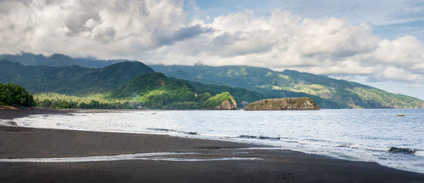 Scenic view of sea and mountains against sky