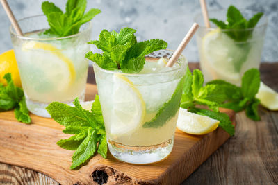 Two glass with lemonade or mojito cocktail with lemon and mint, cold refreshing drink.