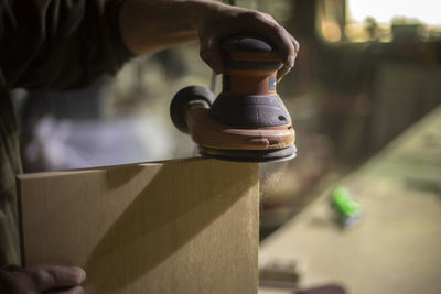Midsection of man holding metal