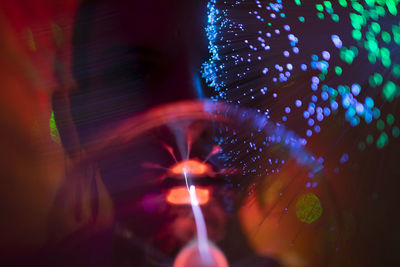 Portrait of beautiful young woman against illuminated background