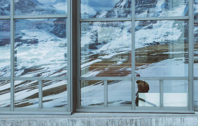 Snow covered landscape seen through glass window