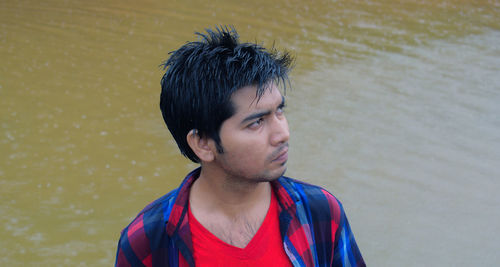 Young man looking away at river