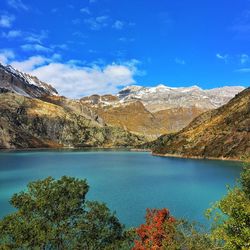 Scenic view of lake and mountains against blue sky