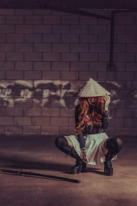 Woman sitting on brick wall