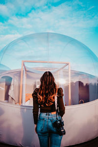 Rear view of woman standing against sky