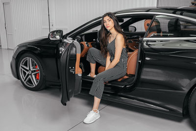 Full length portrait of woman with car
