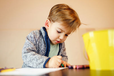 Boy making drawing on table at home