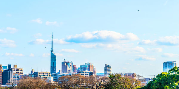 Buildings in city against cloudy sky