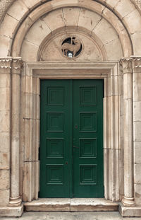 Old green wooden door on stone building
