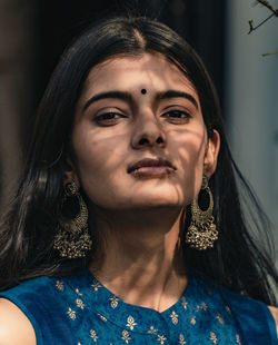 Close-up portrait of beautiful women with shadow of leaves casted on her face 