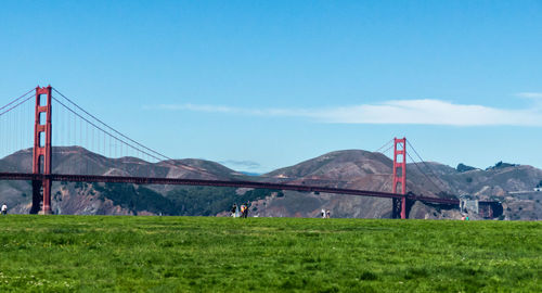 Scenic view of golden gate bridge against mountains and blue sky