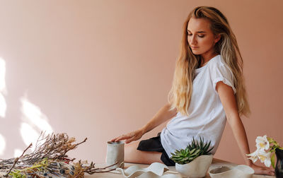 Young woman standing against blue wall