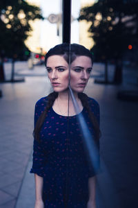 Portrait of young woman standing on street at night